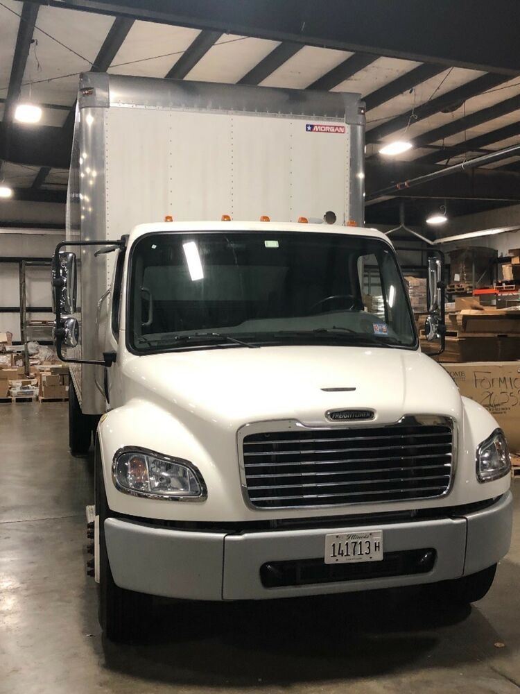 A white box truck parked inside the warehouse, ready at the loading bay.